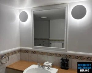 Modern bathroom with a large mirror and sink.